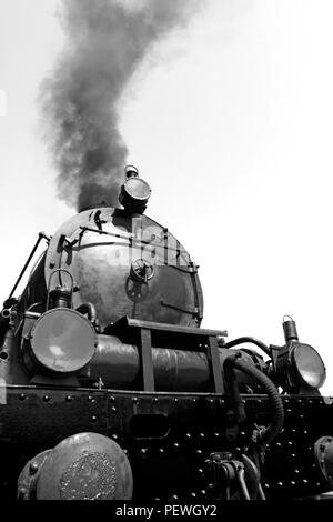 Detail der Vintage Dampfmaschine, Arbeiten, mit Rauch, gegen den blauen Himmel - in Schwarz umgewandelt und Weiß Stockfoto