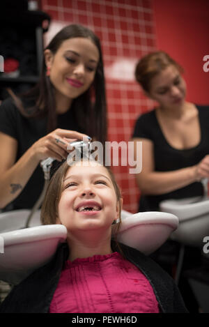 Friseure mit kleinen Mädchen, Haare waschen im Waschbecken