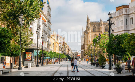 Sevilla, Spanien - 15. Juli 2018: Fußgänger auf der Constitution Avenue mit iconic Sevilla Kathedrale im Hintergrund Stockfoto