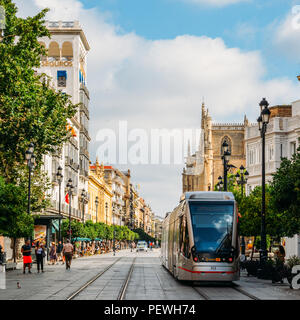 Sevilla, Spanien - 15. Juli 2018: Elektrische Straßenbahn auf der Constitution Avenue mit iconic Sevilla Kathedrale im Hintergrund Stockfoto