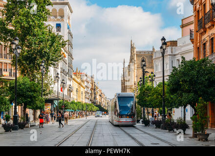 Sevilla, Spanien - 15. Juli 2018: Elektrische Straßenbahn auf der Constitution Avenue mit iconic Sevilla Kathedrale im Hintergrund Stockfoto