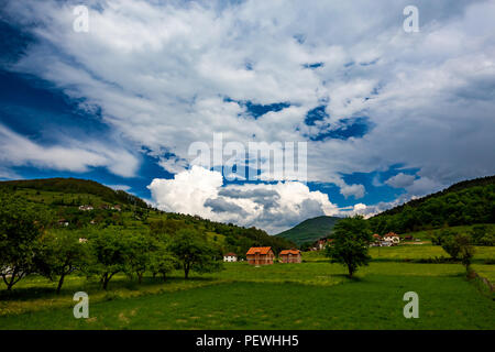 Serbische ländlichen Dorf grün frühling Landschaft, Berge in Serbien sind sehr schön, in der Nähe von valjevo. Tal und die Hügel. Weiße und rote Häuser, farmla Stockfoto