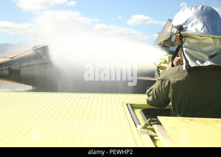 Pfc. Randy Gutierrez, eine Rettung Brandbekämpfung Revolver Operator mit Kaneohe Bay Marine Corps Air Station, Brände ein Wasser Canon eine simulierte brennenden Flugzeug am Feb 9, 2016 zu kühlen. Die Mission von ARFF ist Eigentum zu schützen und zu leben, was bedeutet, dass die Marines müssen geeignet sein und sich innerhalb von Sekunden von einem Anruf sparen. ARFF rescue Männer arbeiten zusammen Flugzeugbränden, Haus zur Vermeidung von Bränden und anderen Notfällen auf den Flugplatz und auf Unterseite. (Marine Corps Foto von Lance Cpl. Jesus Sepulveda Torres) Stockfoto