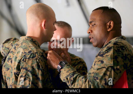 Us Marine Corps Sgt. Maj. Devon A. Lee, Camp Hansen Sergeant Major, unterstützt Generalleutnant Larry D. Nicholson, Kommandierender General für III Marine Expeditionary Force in Fixieren eine gefördert Sgt. Harris Johnson während der Werbeaktion Zeremonie als Teil der Kommandostellenübung (CPX) 16 auf Okinawa, Japan, Feb 2, 2016. CPX 16 durchgeführt, um die Fähigkeiten des III MEF in Intelligenz und logistische Abläufe zu verbessern, die künftige Planung und Bekämpfung der Bereitschaft. (U.S. Marine Corps Foto von MCIPAC bekämpfen Kamera Lance Cpl. Damon A. Mclean/Freigegeben) Stockfoto