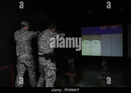 U.S. Army Reserve Soldaten der 363. Military Police Company aus Grafton, W. Virginia, Ziel nehmen, während Sie das Engagement Fähigkeiten Trainer 2000, Feb 2, 2016 at Camp Bondsteel, Kosovo. Das EST 2000 ist ein Indoor, multipurpose Waffen simulator Das spart Munition Ressourcen. Die Soldaten im Camp Bondsteel sind als Teil der NATO-Friedensmission im Kosovo eingesetzt. (U.S. Armee Foto von Sgt. Gina Russell, multinationalen Battle Group-East) Stockfoto