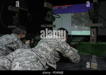 U.S. Army Reserve Soldaten der 363. Military Police Company aus Grafton, West Virginia, Ziel nehmen, während Sie das Engagement Fähigkeiten Trainer 2000, Feb 2, 2016 at Camp Bondsteel, Kosovo. Das EST 2000 ist ein Indoor, multipurpose Waffen simulator Das spart Munition Ressourcen. Die Soldaten im Camp Bondsteel sind als Teil der NATO-Friedensmission im Kosovo eingesetzt. (U.S. Armee Foto von Sgt. Gina Russell, multinationalen Battle Group-East) Stockfoto