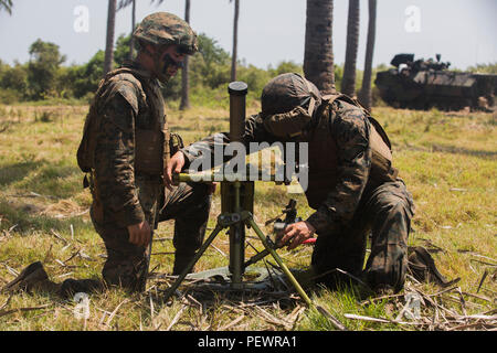 Us Marine Corps Lance Cpl. Gilbert Chavez, rechts, und Lance Cpl. Hunter Vaughn, beide Mörtel Mann mit Golf Company, 2nd Battalion, 4th Marine Regiment, bis eine simulierte firing Position während einer gemeinsamen simulierten Amphibisches mit Indonesischen marines während der Landung Kraft Zusammenarbeit flott Bereitschaft und Weiterbildung (LF KARAT) 2015 auf Bama Strand, Ost Java, Indonesien, Aug 8, 2015. LF CARAT ist dazu gedacht, zu stärken, die die Interoperabilität der amphibischen Planung und Betrieb und die zentralen Fähigkeiten zwischen den Vereinigten Staaten und den Ländern Indonesien, Malaysia und Thailand. (U.S. Mar Stockfoto