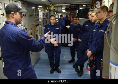 Petty Officer 2nd class Keith Bryan, eine Maschinen Techniker in den Hauptantrieb Division das Patrouillenboot der Polar Star, erklärt Simulation Verfahren vor engineering Unfall Übungen während der Fahrt in der Ross Sea, in der Nähe der Antarktis, Feb 4, 2016. Bryan und andere Prüfer beobachtet wie Engineering watchstanders der Cutter auf Simulierte Beschädigungen Maschinenanlage des Schiffes reagiert. (U.S. Coast Guard Foto von Petty Officer 2. Klasse gewähren DeVuyst) Stockfoto