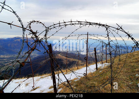 Veneto, Italien. Massiv des Mount Grappa. Mount Palon : italienischer Stacheldraht an der Front, heute Teil des großen Freilichtmuseums des Ersten Weltkriegs, Fluss Piave im Hintergrund. --Veneto, Italien. Massiccio del Grappa. Monte Palon, filo spinato italiano sulla prima linea, subito sotto si vede il monte Tomba più volte conquistato e perduto dalle truppe austro-ungariche. IL Tomba Fu strenuamente difeso dai fanti francesi. Nella pianura Scorre il Piave. Restauri effettuati nell'ambito del progetto del museo all' aperto della grande Guerra. Stockfoto