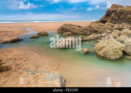 Eine der vielen Felsformationen ermöglicht eine tiefe Pool auf die weite offene Strand auf Sandymouth in North Cornwall zu bilden. Stockfoto