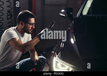 Man prüft die Polieren mit einer Taschenlampe Stockfoto