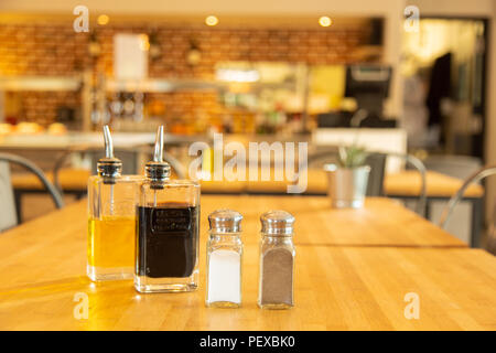 Pfefferstreuer und Salt Shaker mit Flaschen Essig und Öl auf ein Bambus Tisch Stockfoto