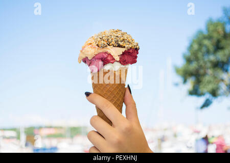 Weibliche hand Eis mit Schokoladensauce und Cookies Stockfoto