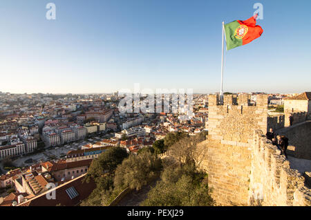 Die Portugiesische Flagge fliegt von den Mauern des Castelo de São Jorge über das Stadtbild von Lissabon. Stockfoto