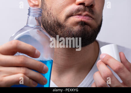 Close-up ein Mann seinen Mund mit Mundwasser Ausspülen Stockfoto