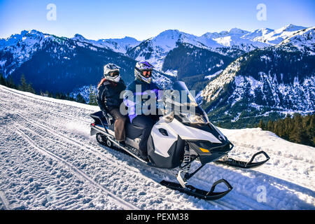 Mann und Frau, snowmobile im Callaghan Valley, Whistler, British Columbia, Kanada Stockfoto