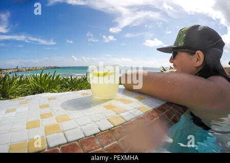 Frau in Oceanside Pool mit Cocktailbar Stockfoto