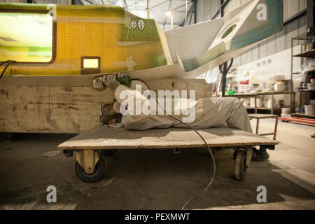 Mann mit Schleifer beim Errichten von Schiff, Lorient Keroman Submarine Base, Bretagne, Frankreich Stockfoto