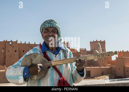 Berber Mann spielt Instrument für Touristen in Marokko Stockfoto