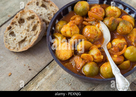 Frische Rosenkohl hausgemachte Keramik Schüssel auf natürliche Holz- Hintergrund geröstet. Stockfoto