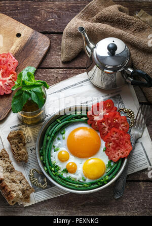 Sonnenseite Spiegelei in einer Kupfer Pfanne mit Tomaten und grünen Bohnen, kopieren. Stockfoto