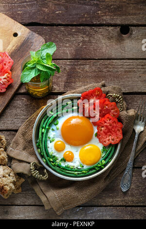 Sonnenseite Spiegelei in einer Kupfer Pfanne mit Tomaten und grünen Bohnen, kopieren. Stockfoto