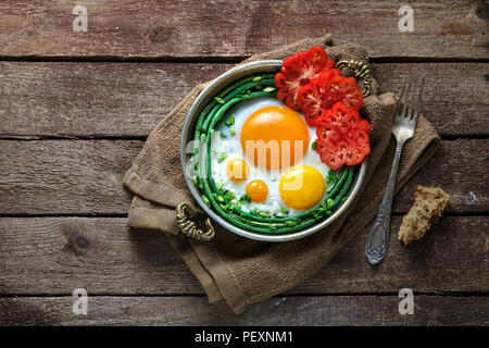 Sonnenseite Spiegelei in einer Kupfer Pfanne mit Tomaten und grünen Bohnen, kopieren. Stockfoto