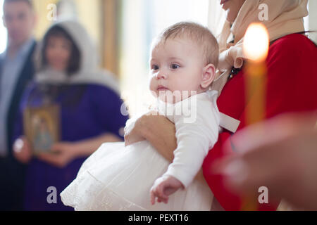 Belarus, Gomel, 29. April 2018. Kirche auf dem Wolotowo-Feld. Die Taufe des Kindes. ein Kind im Ritus der Taufe. In den Armen meiner Mutter. Annahme des Glaubens Stockfoto