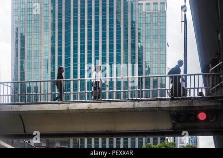 BANGKOK, THAILAND - 6. Juli 2017 - Fußgänger Nutzung Fußgängerbrücke belebten Straße in der geschäftigen Stadt von Bangkok, Thailand am 6. Juli, 2017 Stockfoto