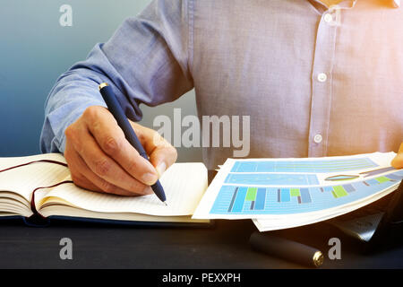 Unternehmer ist das Schreiben von Mitteilungen im Notepad. Arbeiten mit Dokumenten. Stockfoto