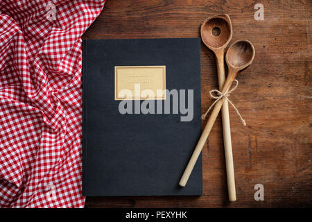 Rezepte kochen Buch. Notebook, Küchengeräte und roten Tischdecke auf Holztisch, Ansicht von oben Stockfoto