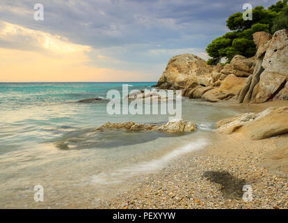 Sonnenstrahlen durch die Wolken über erstaunliche Koviou Strand und schöne rock Struktur Stockfoto