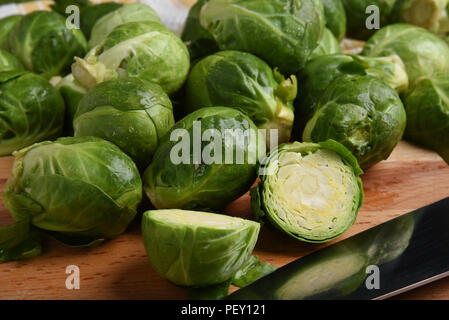 Nahaufnahme von Rosenkohl auf einem Schneidebrett geschnitten werden Stockfoto