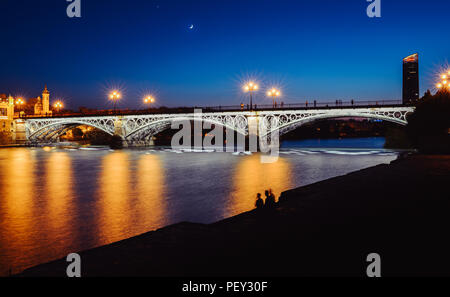 Lange Belichtung blaue Stunde Blick von Puente de Triana oder Triana Brücke in Sevilla, Andalusien, Spanien Stockfoto