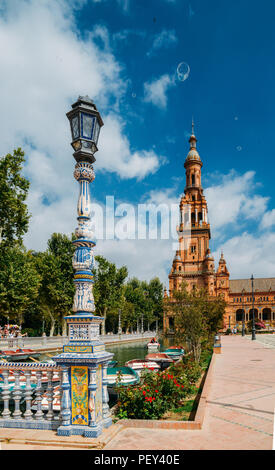 Sevilla Spanien - 15. Juli 2018: Gegenüberstellung von blau und weiß Keramik Azulejo Kacheln gegen eine der barocken Sandstein Turm an der Plaza de Espana in Stockfoto