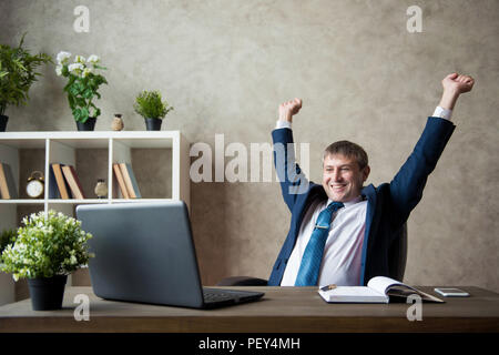 Happy begeistert junge Unternehmer sitzen am Arbeitsplatz und Erfolge feiern Stockfoto