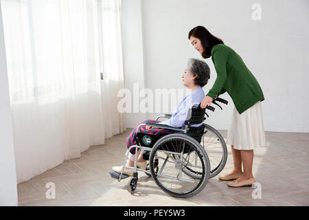 Foto der Krankenschwester, die Unterstützung der älteren Frau sitzt auf einem Rollstuhl. Altenpflege Konzept Foto. 008 Stockfoto