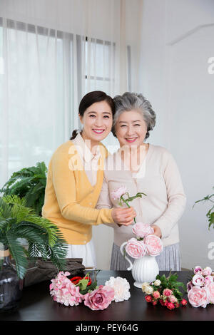 Ältere Mutter und Tochter die Blumendekoration auf Tisch. 036 Stockfoto