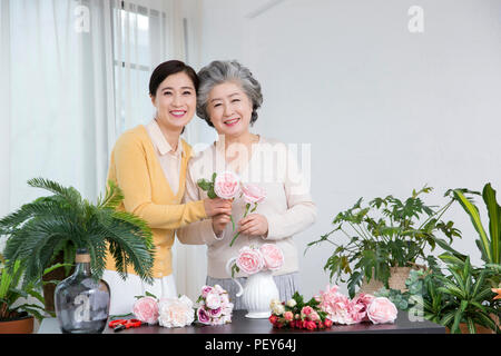 Ältere Mutter und Tochter die Blumendekoration auf Tisch. 035 Stockfoto