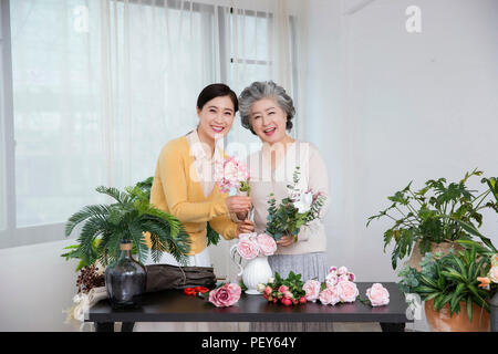 Ältere Mutter und Tochter die Blumendekoration auf Tisch. 033 Stockfoto