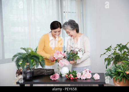 Ältere Mutter und Tochter die Blumendekoration auf Tisch. 032 Stockfoto