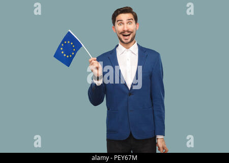 Zeit für Europa. Stattliche erstaunt Geschäftsmann in blaue Jacke und weißes Hemd, die Fahne der Europäischen Union und die Kamera mit gewundert. Indo Stockfoto