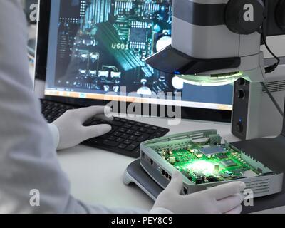 Ingenieur mit einem Stereo Mikroskop eine Leiterplatte während der Prozess der Qualitätskontrolle zu überprüfen. Stockfoto
