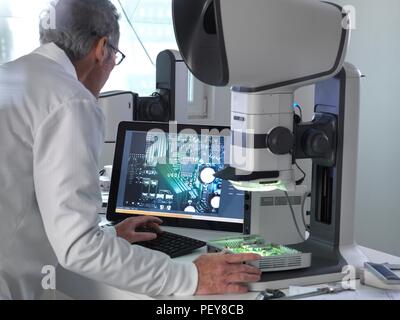 Ingenieur mit einem Stereo Mikroskop eine Leiterplatte während der Prozess der Qualitätskontrolle zu überprüfen. Stockfoto