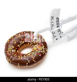 Das Nähren, konzeptionelle Bild. Schokolade Donut mit Hautfalte Bremssattel. Stockfoto