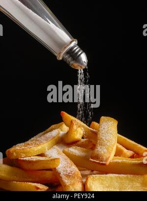 Salz Gießen auf Chips. Stockfoto