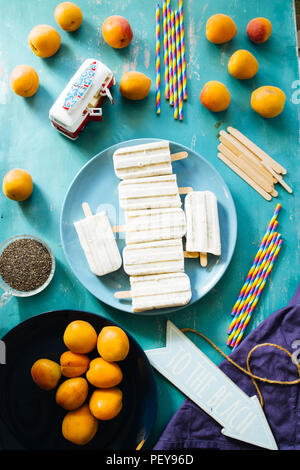 Popsicle, Sommerzeit Konzept, Bündel von Zitrone, Aprikose und Chia Samen Eis am Stiel auf blauem Teller, um einen Strand Symbol, Aprikose und Chia Samen und Stra Stockfoto