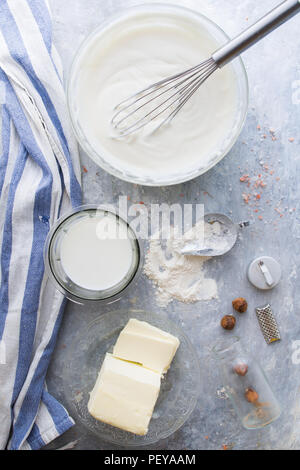 "Bechamelsauce' Sauce ist eine typische cram aus Milch, Butter und Weizen, hier eine Schüssel voller bereit besciamlla und Zutaten zu machen, Ansicht von oben. Stockfoto