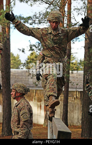 Pfc. Cody Kildow, (rechts), ein infanterist zum Hauptsitz und Sitz Truppe, 3 Staffel, 2 Cavalry Regiment zugeordnet, navigiert ein Hindernis beim Aufwärmen für multinationale schnelle Seil Einarbeitung training, 24.02.16, bei Adazi Militärbasis, Lettland. Soldaten lief durch einen kurzen Hindernisparcours vor, die in den Turm, ihre Körper für erforderliche Bewegungen während des schnellen Seil im Einsatz vorbereiten. Lettische Partner in der Ausbildung neben den amerikanischen Verbündeten in der Vorbereitung für eine bevorstehende schnelle Seil Operation zur Unterstützung der Operation Atlantic lösen, eine multinationale Dm teilgenommen Stockfoto