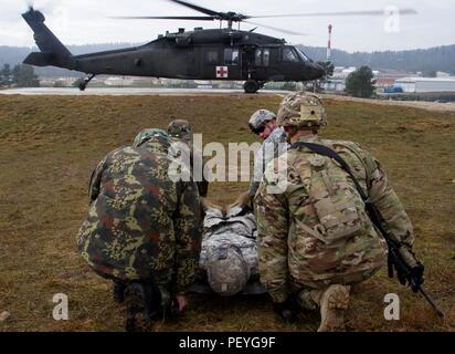 Us-Armee Soldaten aus dem ersten Bataillon, 41 Infanterie Regiment, 2 Infantry Brigade Combat Team, 4 Infanterie Division arbeiten neben Mitgliedern der albanischen Streitkräfte einen simulierten Unfall in eine UH-60 Black Hawk während medevac Training zu laden Feb.18, bei der Gemeinsamen multinationalen Readiness Center in Hohenfels, Deutschland. Die Soldaten, die aus Fort Bragg, N.C. stationiert sind, sind Schulungen neben USA und multinationalen Partnern in Vorbereitung für Kosovo Force 21 zur Unterstützung der Multinationalen Battle Group-East. MNBG-E ist zur Gewährleistung eines sicheren und geschützten Umfelds gewidmet, und die Freiheit der m Stockfoto